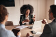 © Jelena - Confident Businesswoman Leading an Engaging Professional Meeting in the Workplace