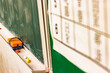 © hakofac - 黒板に並ぶ黒板消しとチョークの学校教室の静かな一場面／Eraser and chalk on classroom blackboard in quiet school scene