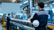 © wanavit - Foreman work factory supervisor watches automated production line with helmet arm focused quality control and efficiency