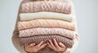 © ArtStock - Female hands holding stack of knitted sweaters