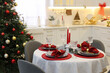 © New Africa - Festive table setting with Christmas decor in kitchen. Interior design