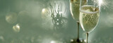 Two filled champagne glasses at elegant modern style with soft green new year's eve background and a clock. Space for text.
