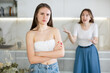 © JackF - Upset teen girl standing in the kitchen, cross mother scolding her standing behind
