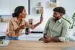 © Miljan Živković - Couple having conflict showing smart phone in modern kitchen