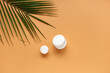 © Pixel-Shot - Jars of cream and palm leaf on color background