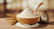 © Mey - A wooden bowl filled with white flour, a wooden spoon, and wheat ears on a wooden table.