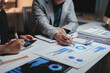 © crizzystudio - Business professionals analyzing financial data reports late