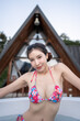 © marchsirawit - Woman in pink bikini relaxing in the bathtub outdoor.