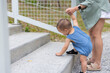 © leungchopan - Mother helping baby walk on stairs at park