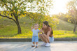 © leungchopan - Mum holding baby hand at park under beautiful sunshine