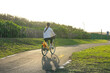 © leungchopan - Woman riding bike under sunshine at park