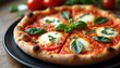 © Vadym - Whole pizza margherita with tomatoes mozzarella and basil on black plate. Close up view of baked italian food with crispy crust on wooden table. Ready to eat.