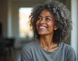 © Vadym - Mature African American woman with curly gray hair smiles warmly. Her healthy skin glows, looking up with joyful expression. She is wearing a simple gray t-shirt.