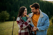 © La Famiglia - Romantic couple enjoying outdoor date presenting flowers