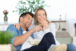 © auremar - young couple laughing while watching tv at home