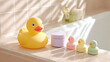 © Liliya - Yellow rubber duck and pastel baby bath toys on a bathtub edge in soft morning sunlight. Cozy bathroom interior, playful and clean atmosphere for kids.