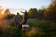 © Johnér - Friends looking at sunset while standing around bench at park