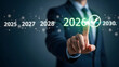 © SUKANTO IMAGE  - Business professional selecting the year 2026 on a futuristic digital display