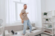 © SHOTPRIME STUDIO - Happy man dancing at home, enjoying a digital detox and embracing work-life blur, showcasing authentic imperfection in solo living and mental health awareness.