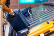 © unai - Passenger picking up luggage from airport baggage claim carousel