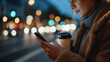 © wolfhound911 - Businesswoman typing on her phone at night in a city setting, working on design, research, or web UI tasks. Outdoor bokeh highlights communication, networking, and deadlines.