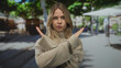 © Krakenimages.com - Blonde woman wearing beige turtleneck sweater crossing hands in x gesture on street; denial rejection.