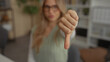 © Krakenimages.com - Woman raising thumb up then thumb down in office to show positive and negative feedback; approval disapproval decision.