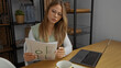 © Krakenimages.com - Young woman wearing glasses holds a printed report sheet at a wooden desk in building with focused expression; analysis focus.