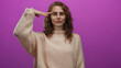 © Krakenimages.com - Woman posing with a salute gesture against a vibrant pink background wearing a cozy sweater, expressing calm and confidence.