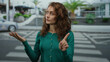 © Krakenimages.com - Woman with curly hair wearing a green sweater expresses disapproval with hand gestures on a city street, showcasing urban life and casual outdoor fashion.