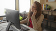 © Krakenimages.com - Woman in office experiencing toothache while seated at a desk with a computer, showcasing stress and discomfort, surrounded by organized workspace elements and natural lighting.