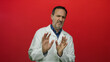 © Krakenimages.com - Hispanic man in white coat expressing discomfort against vivid red background, showcasing emotions through facial expressions and gestures, capturing a moment of reluctance.