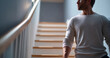 © perfectlab - Young man in casual clothing sitting on stairs indoors looking thoughtfully to the side with soft natural lighting
