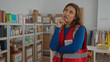 © Krakenimages.com - Young woman volunteer pondering in charity center surrounded by donation boxes indicating thoughtful decision-making process indoors