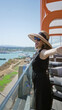 © Krakenimages.com - Young woman wearing straw sunhat and sunglasses, arms outstretched on a cruise terrace building; vacation joy.