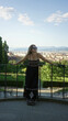 © Krakenimages.com - Woman standing with arms outstretched on viewpoint railing in florence wearing black sundress and sunglasses, bare feet visible; serenity.