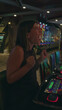 © Krakenimages.com - Woman young hispanic brunette at slot machine presses button while smiling, watching colorful reels and lights in a casino building; winning excitement.