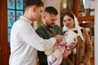 © New Africa - People with child during baptism ceremony in church