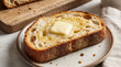 © MYKHAILO KUSHEI - Toast adorned with glistening butter on a ceramic plate awaits a delightful morning bite