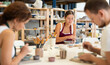© JackF - Pottery workers paint ceramic plates together at a table