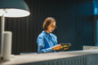 © Miljan Živković - Woman designer reading sample book in modern office
