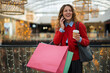 © Jelena - Happy woman talking on phone enjoying shopping in mall