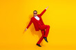 © deagreez - Energetic man in red suit leaps against bright yellow background creating a fun stylish moment for fashion and promotion