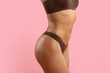 © Anastasiya - Torso of young black woman in brown underwear on pink background. Defined waist, smooth curves and toned physique perfect for fitness, wellness and lingerie themes