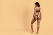 © Anastasiya - Rear view of fit young black woman in brown underwear on beige studio background. Fit curves, toned muscles and smooth skin ideal for beauty, body sculpting, weightloss and fitness themes