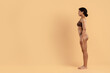 © Anastasiya - Side profile shot of young slim black woman in brown underwear. Defined waist, toned hips and sculpted glutes reflect fitness or weightloss progress and modern beauty care routines