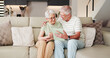 © peopleimages.com - Senior couple, relax and hug with tablet on sofa for bonding, entertainment or streaming in home. Elderly, man and woman with smile on technology for network, subscription or app on couch in house