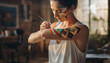© Murda - woman applying colorful geometric patterns to her arm with brush.