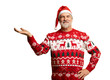 © opolja - Merry mature man wear knitted christmas sweater Santa hat presenting something on transparent background. New year shopping idea concept. New Year 2026 Christmas