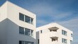 © R.Fauzi - Modern white apartment buildings with large windows against a blue sky